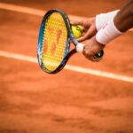 Close-up of a tennis player preparing to serve on a clay court in Montevideo.